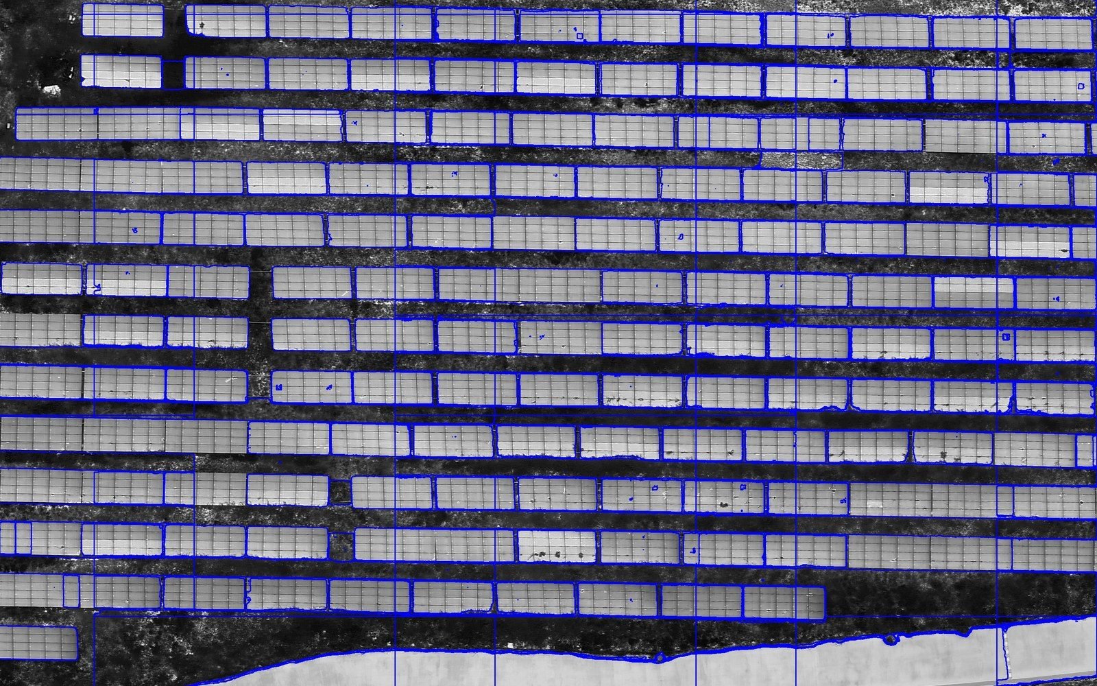 A detail of a second orthophoto in which Segment Anything has outlined most panel tables in blue; straight lines mark the tile boundaries